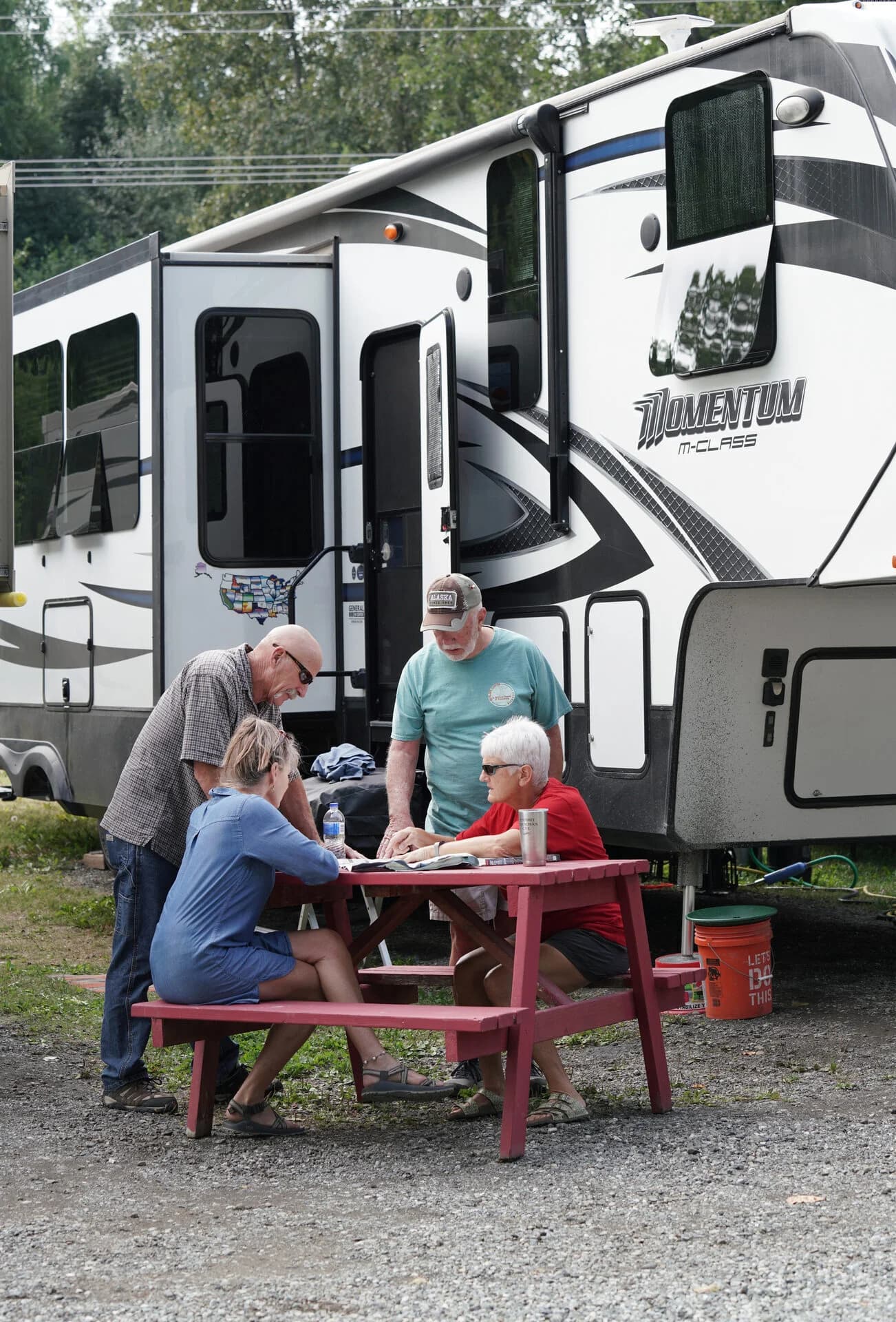 Guests at picnic table with RV in background